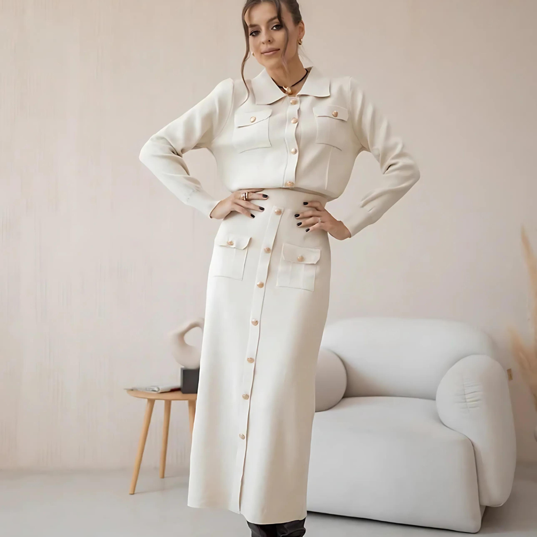 Frau in stilvollem Set Celly in Weiß, bestehend aus einem Strick-Blazer und einem passenden Rock, in Vorderansicht. Das elegante, Vintage-inspirierte 2-teilige Set bietet eine feminine Silhouette und ist ideal für Büro, Freizeit und besondere Anlässe in der Herbst- und Wintersaison. Der weiche, hochwertige Strickstoff sorgt für maximalen Tragekomfort.