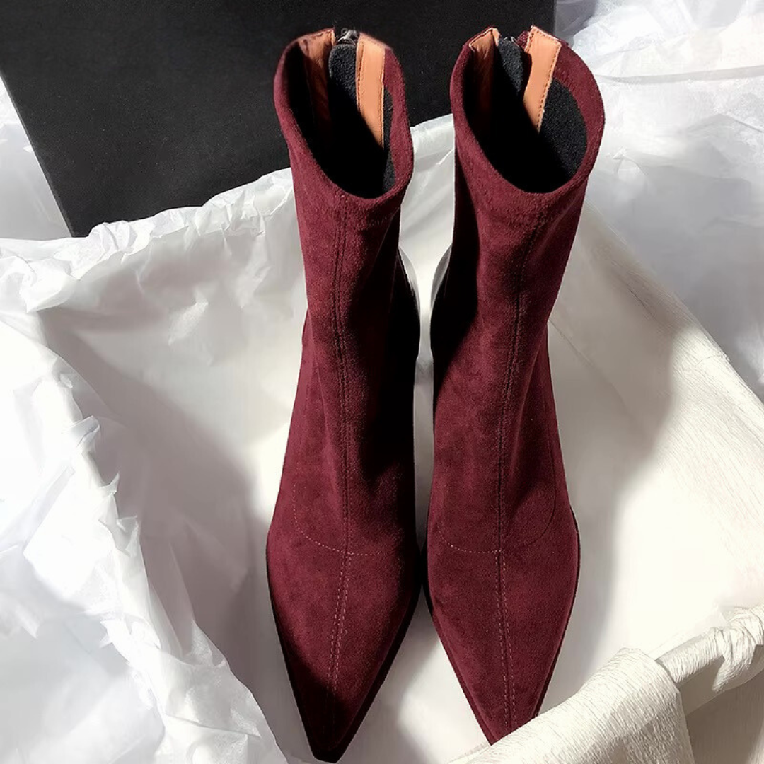 Bordeauxfarbende Stiefeletten stehend in einem Schuhkarton