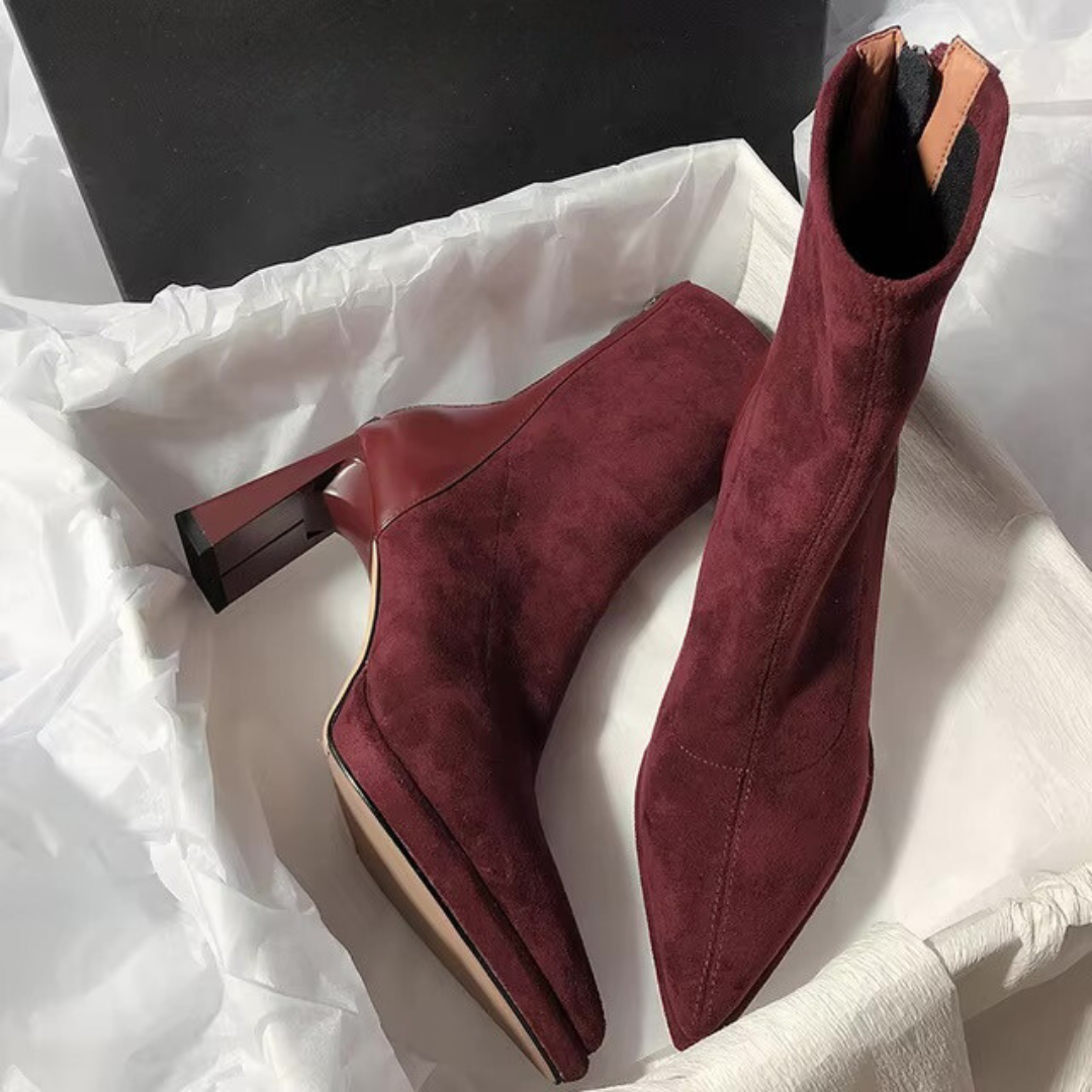 Bordeauxfarbene Stiefeletten in einem Schuhkarton, liegend und stehend