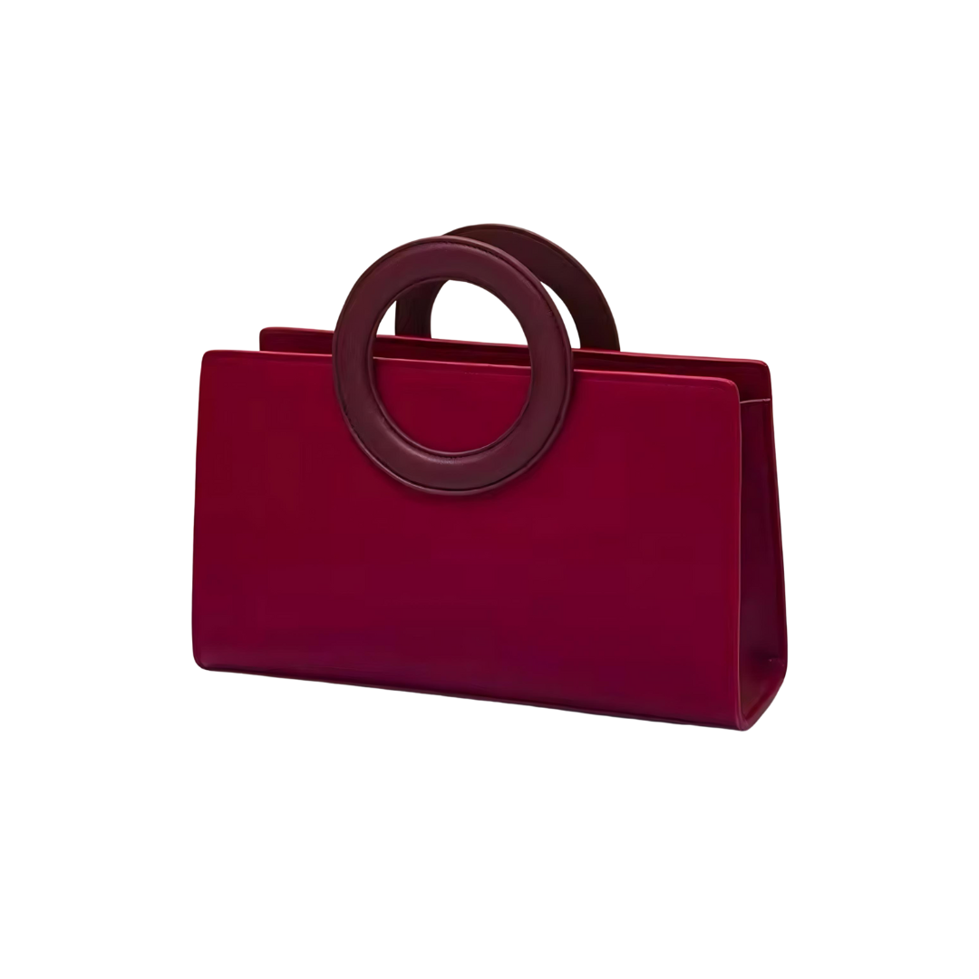 Die Tasche Ruby aus hochwertigem strukturiertem Leder in auffälligem Rot, abgebildet auf einem neutralen Hintergrund. Die Handtasche zeigt ihre elegante Form und Details wie den Magnetverschluss, der die Tasche schließt. Die Tasche kann als Schulter- oder Umhängetasche getragen werden und ist ideal für besondere Anlässe wie Hochzeiten oder Events.