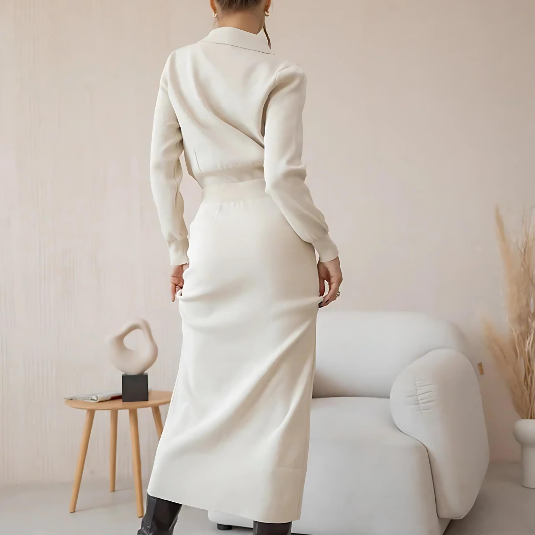 Frau in stilvollem Set Celly in Weiß, bestehend aus einem Strick-Blazer und einem passenden Rock, in Rückansicht. Das elegante, Vintage-inspirierte 2-teilige Set bietet eine feminine Silhouette und ist ideal für Büro, Freizeit und besondere Anlässe in der Herbst- und Wintersaison. Der weiche, hochwertige Strickstoff sorgt für maximalen Tragekomfort.