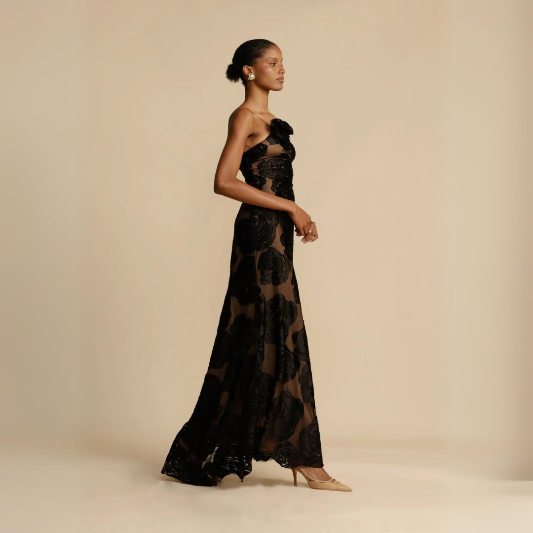 Seitenansicht des eleganten Kleid Mary, das eine stilvolle Ein-Schulter-Silhouette und eine figurbetonte Bodycon-Passform zeigt. Die hohe Taille und das zarte Blumenmuster betonen die schlanke Silhouette und Weiblichkeit.