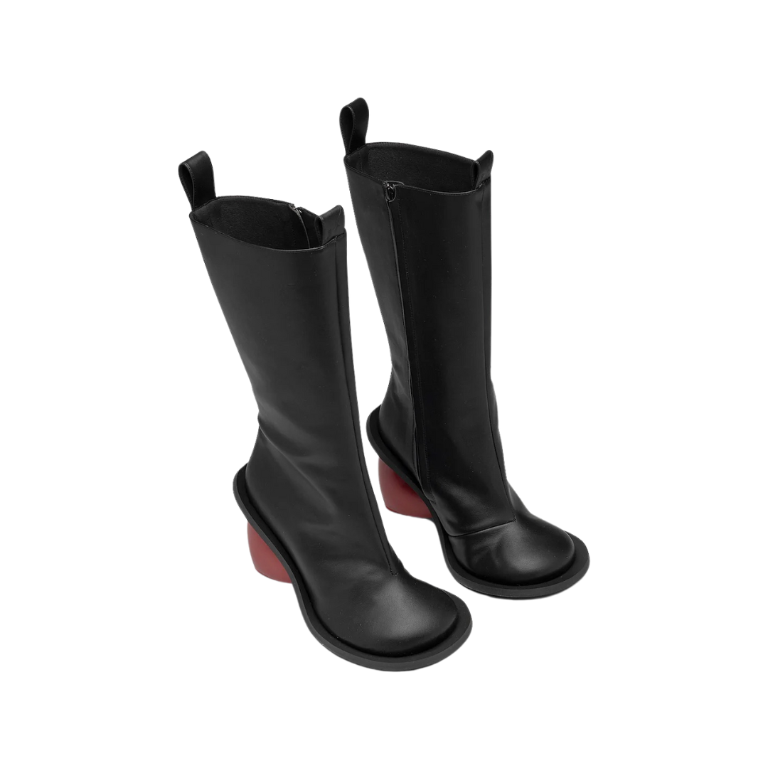 Vorderansicht der Love Heels Boots auf neutralem Hintergrund. Die trendigen Damenstiefel mit Reißverschluss und Rundkopf-Design sind im knielangen Schnitt zu sehen, der das luxuriöse und stilvolle Aussehen der roten Herz-Absätze betont.