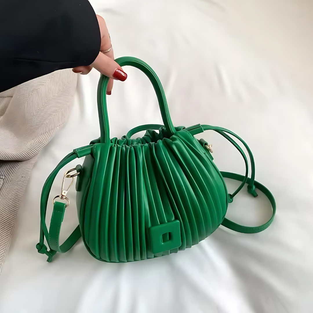 Frau hebt die grüne Vintage Umhängetasche aus PU-Leder leicht am verstellbaren Schulterriemen an. Die elegante Tasche zeigt ihren luxuriösen Vintage-Stil und die großzügige Kapazität für vielseitige Nutzung.