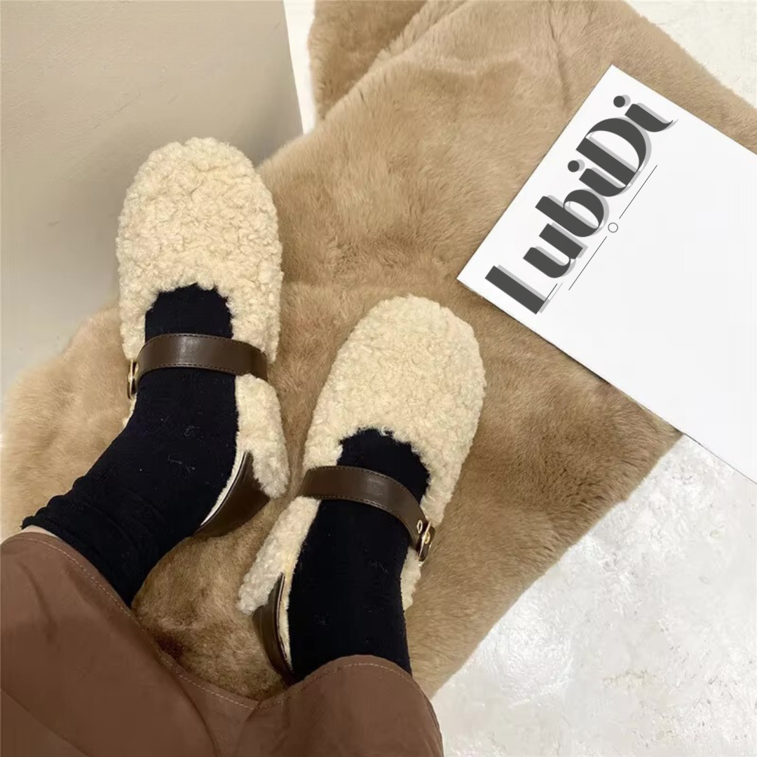 Loafer Teddy in Apricot, getragen von einer Person. Die Schuhe sind in der Vorderansicht abgebildet, zeigen das weiche Lammhaar und das Mary-Jane-Design. Die flache, flexible Sohle und der Slip-On-Stil sind gut sichtbar, ideal für den Komfort an kühlen Tagen.