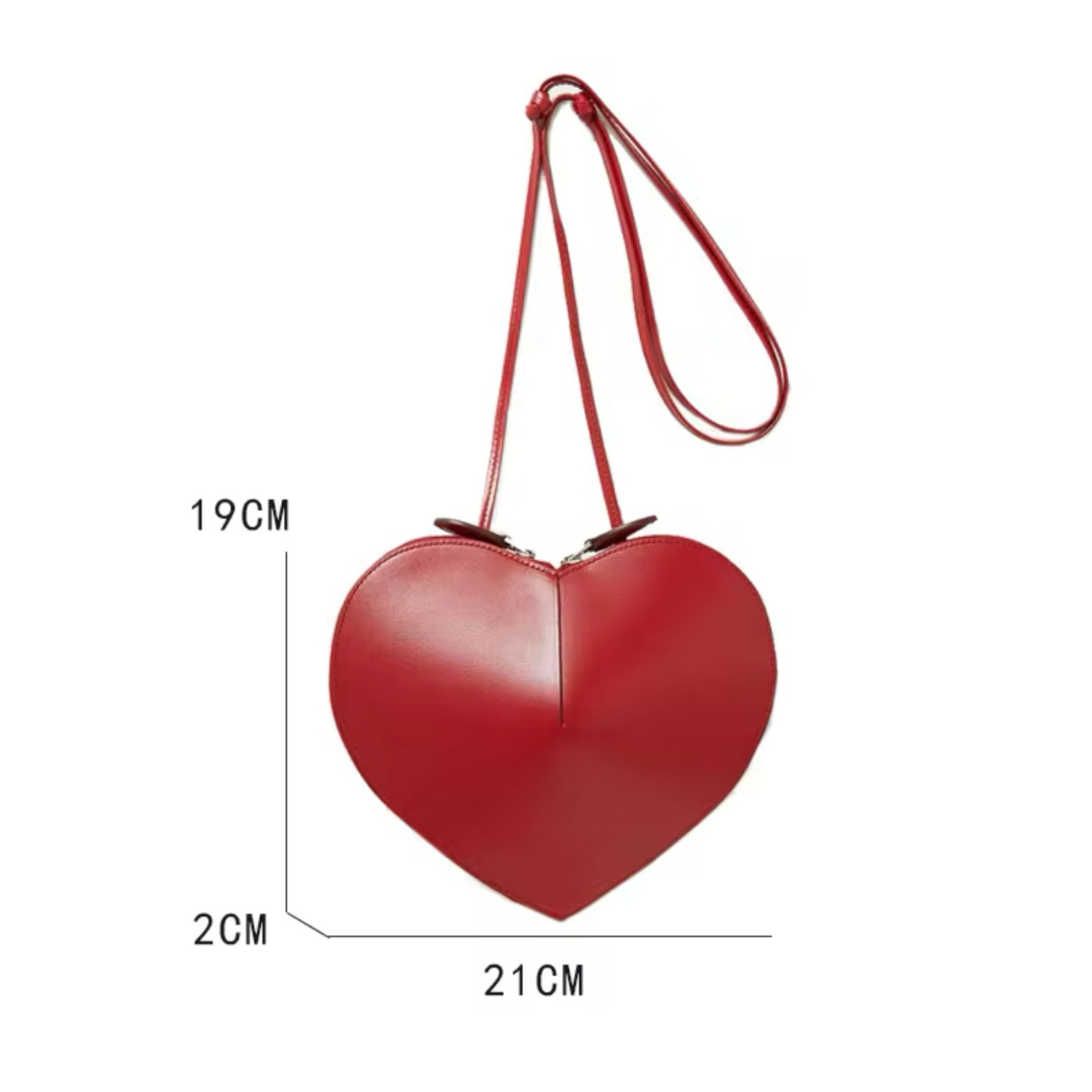 Rote Herz-Tasche auf neutralem Hintergrund mit Breitenangabe 21 cm und Höhenangabe 19 cm. Das Produktbild zeigt die kompakte Größe der Tasche sowie die auffällige herzförmige Silhouette und das edle Design.
