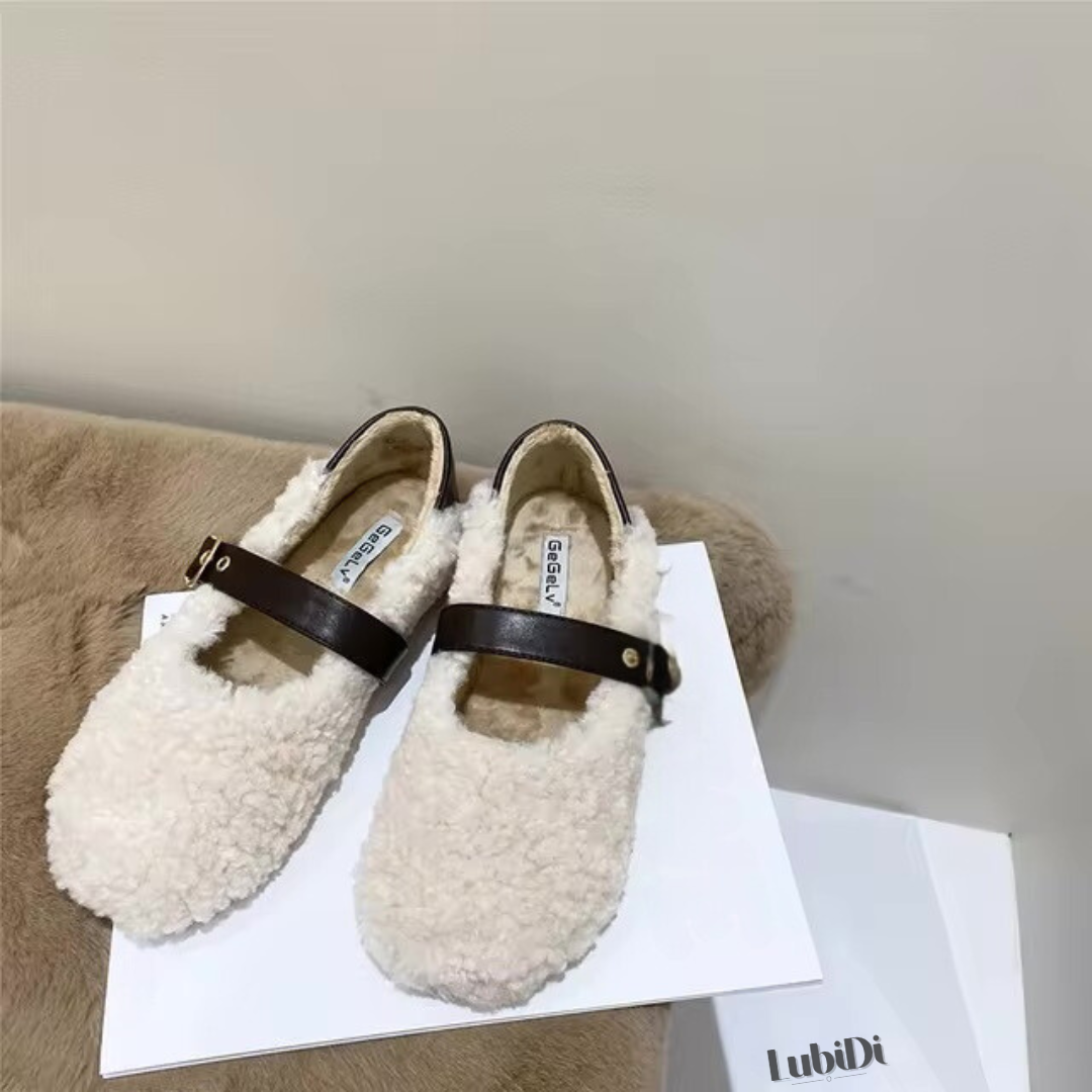 Loafer Teddy in Beige, abgebildet in der Vorderansicht. Das Bild zeigt ein Paar der Schuhe, die aus weichem Lammhaar gefertigt sind und das klassische Mary-Jane-Design aufweisen. Die flache, flexible Sohle und der Slip-On-Stil sind deutlich sichtbar, ideal für den Komfort an kühlen Tagen.